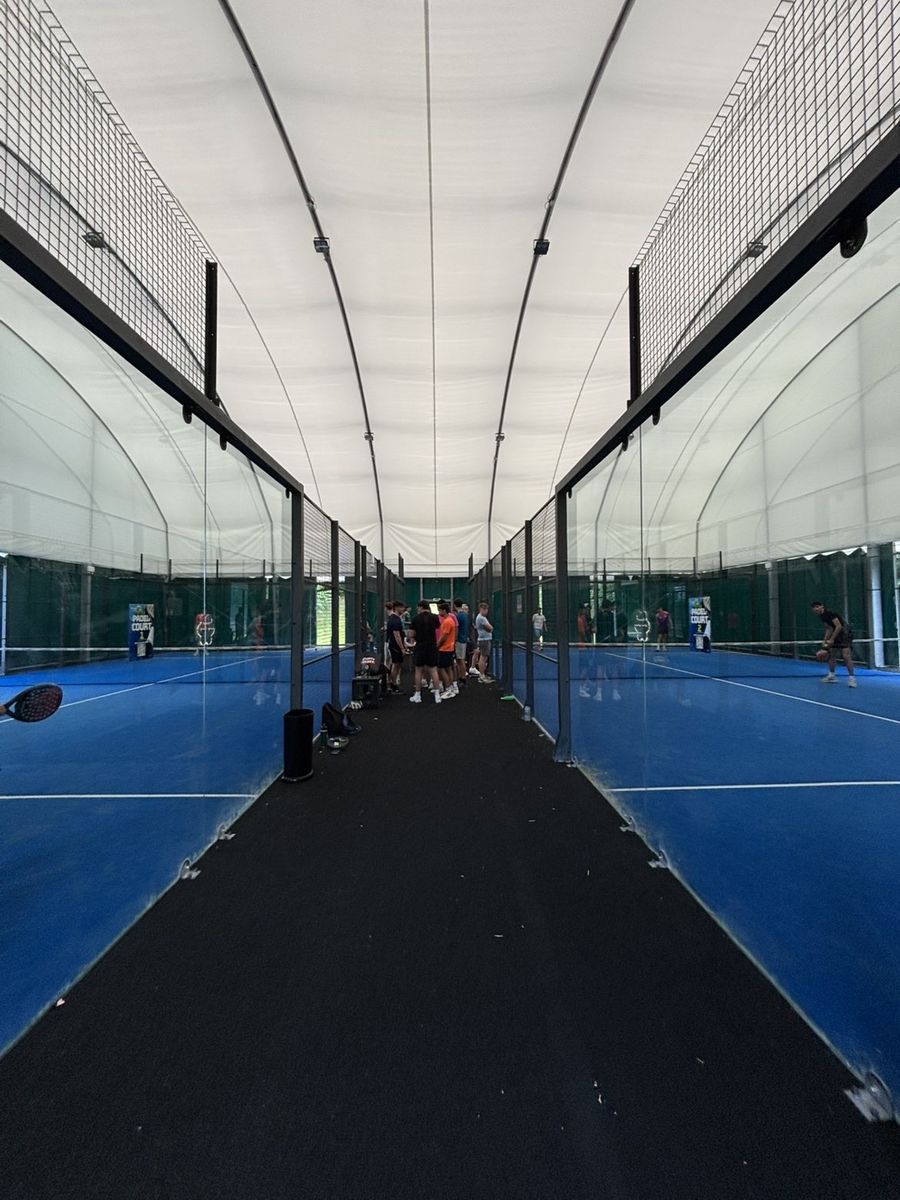 Players gathered between two indoor padel courts